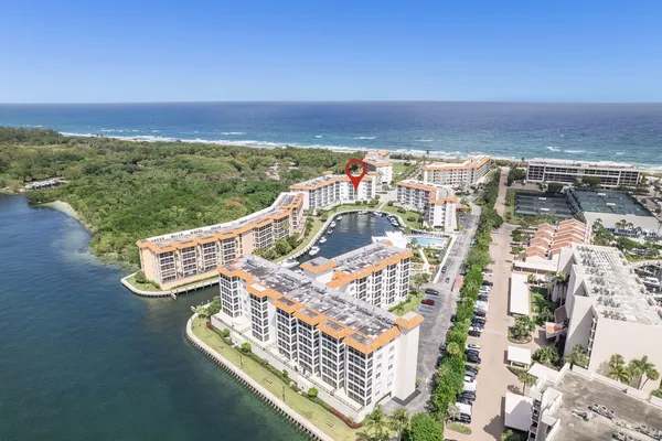an aerial view of ocean and residential houses with outdoor space