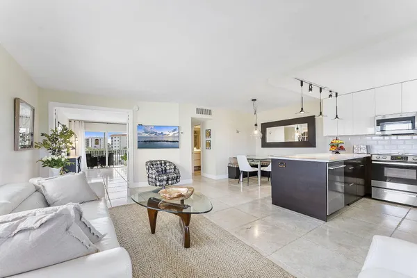 a living room with furniture a dining table and kitchen view