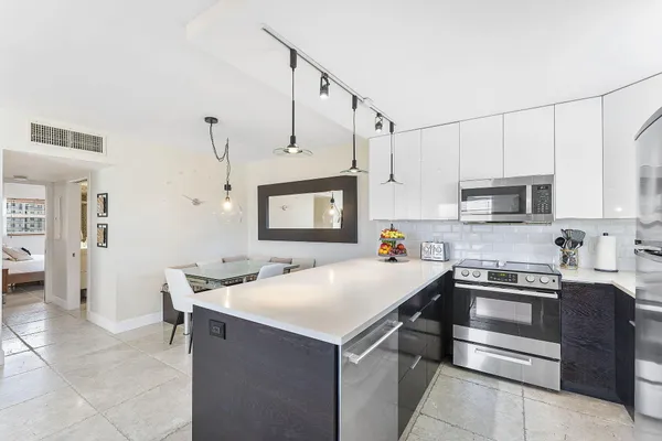 a kitchen that has a lot of cabinets in it and appliances