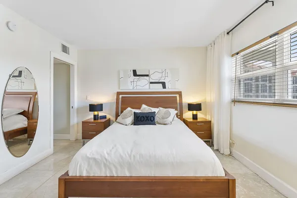 a bedroom with a large bed and a mirror