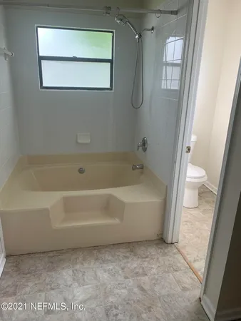 a spacious bathroom with a bathtub and a toilet