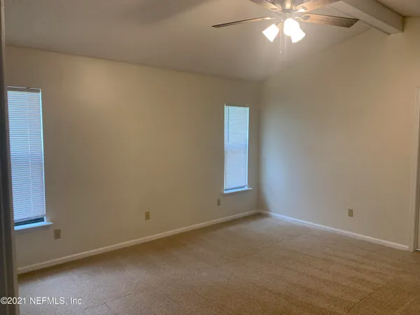 an empty room with a chandelier fan