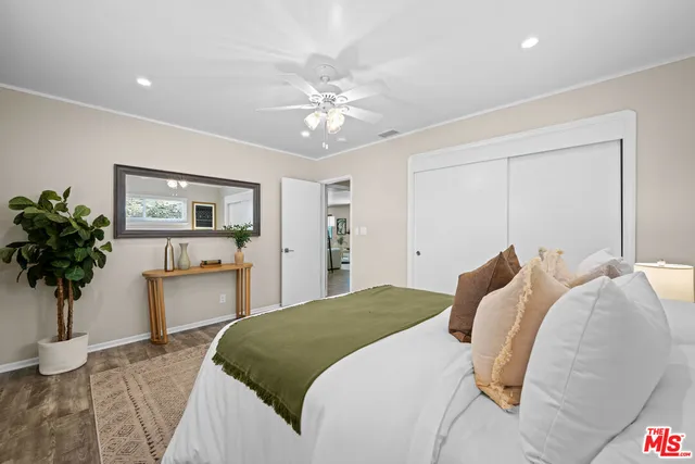 a bedroom with a bed and a potted plant