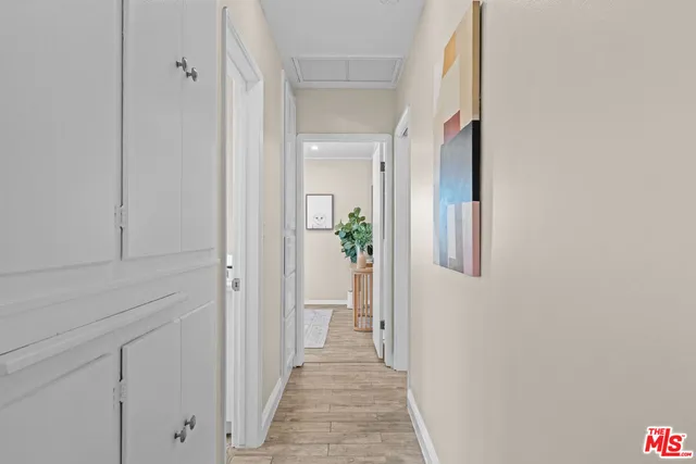 a view of a hallway with wooden floor and closet