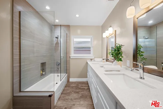 a bathroom with a tub a sink and mirror