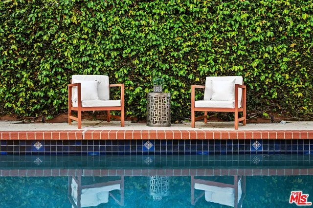 a view of a swimming pool with a lake and trees in the background