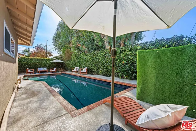 a view of a patio with chairs and a umbrella