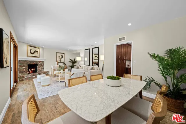 a living room with fireplace furniture and a potted plant