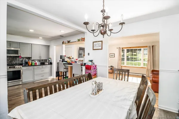 a kitchen with stainless steel appliances kitchen island granite countertop a stove a table and chairs in it