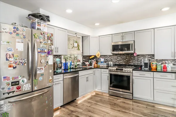 a kitchen with stainless steel appliances granite countertop a stove a sink and a refrigerator