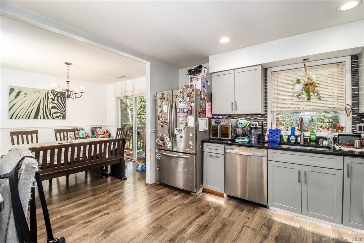 35 Hillendale Drive New Milford, CT 06776 - Photo 18 of 39 a kitchen with stainless steel appliances granite countertop a refrigerator a sink dishwasher a dining table and chairs with wooden floor
