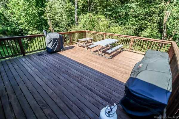 a balcony with wooden floor table and chairs