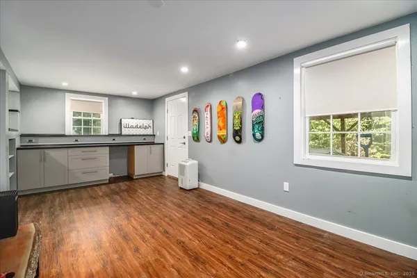 a kitchen with stainless steel appliances granite countertop a stove a sink wooden floor and a window