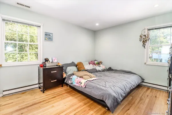 a bedroom with a bed and windows