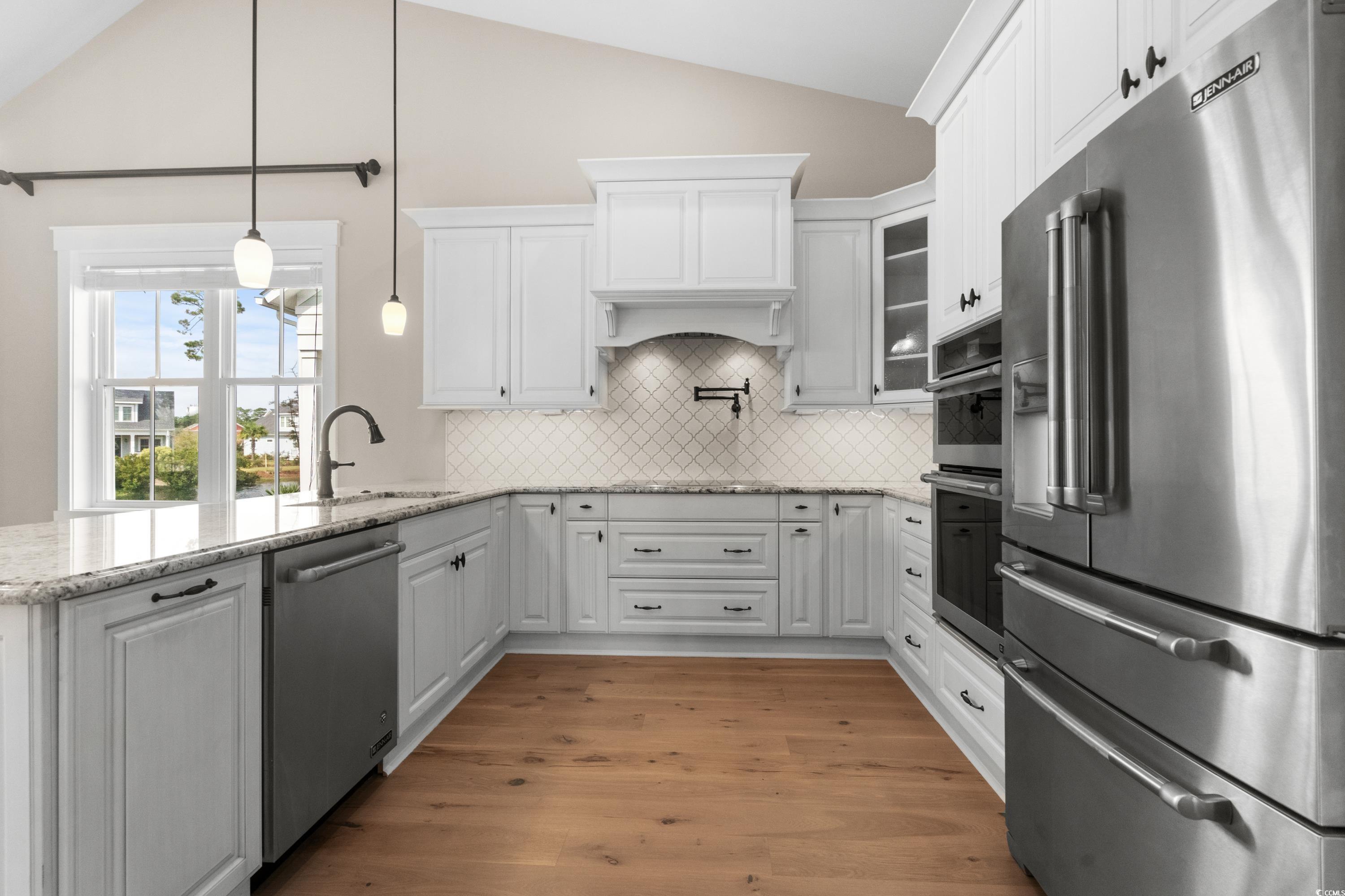 8159 Sandlapper Way Myrtle Beach, SC 29572 - Photo 18 of 39 Kitchen featuring white cabinets, vaulted ceiling,