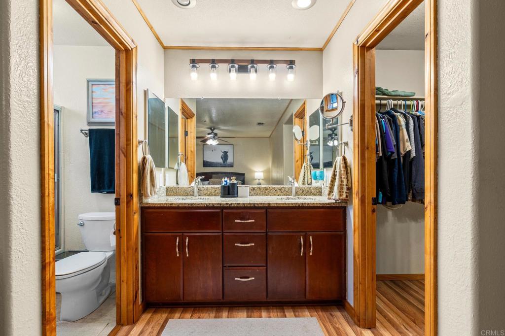 8321 Sheila Street El Cajon, CA 92021 - Photo 11 of 26 a bathroom with a granite countertop sink a toilet and a mirror