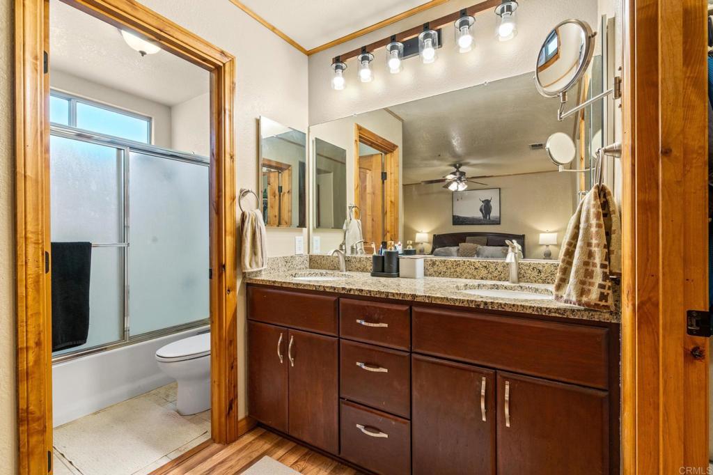8321 Sheila Street El Cajon, CA 92021 - Photo 12 of 26 a bathroom with a granite countertop sink a toilet and a shower