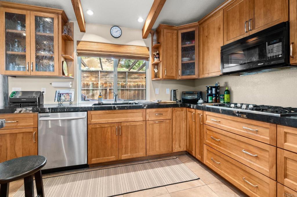 8321 Sheila Street El Cajon, CA 92021 - Photo 7 of 26 a kitchen with stainless steel appliances granite countertop a refrigerator and a stove top oven