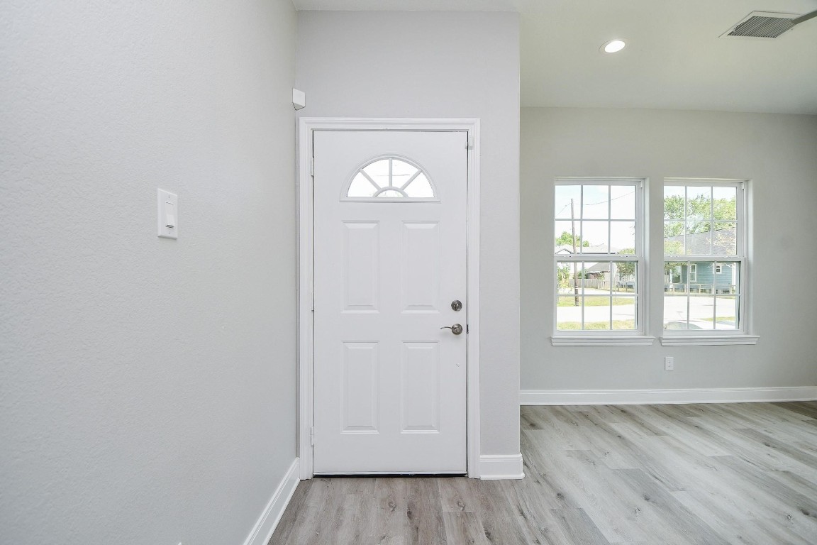 8336 Fountain Street Houston, TX 77051 - Photo 3 of 34 an empty room with wooden floor and windows