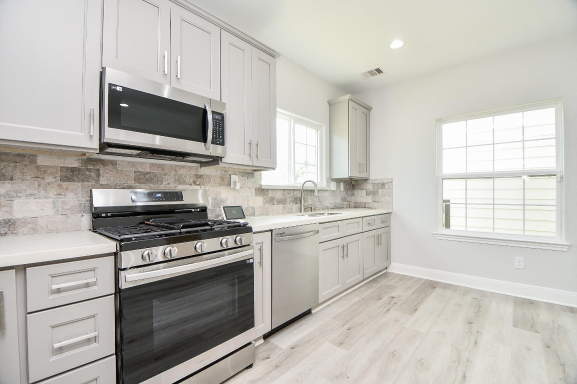 8336 Fountain Street Houston, TX 77051 - Photo 8 of 34 a kitchen with stainless steel appliances a stove microwave and sink