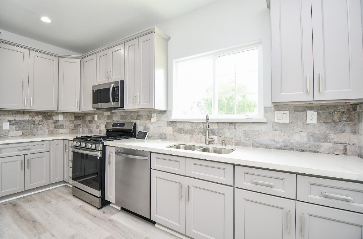8336 Fountain Street Houston, TX 77051 - Photo 9 of 34 a kitchen with cabinets appliances a sink and a window