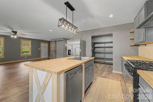 a kitchen that has a sink stainless steel appliances a counter space and a window