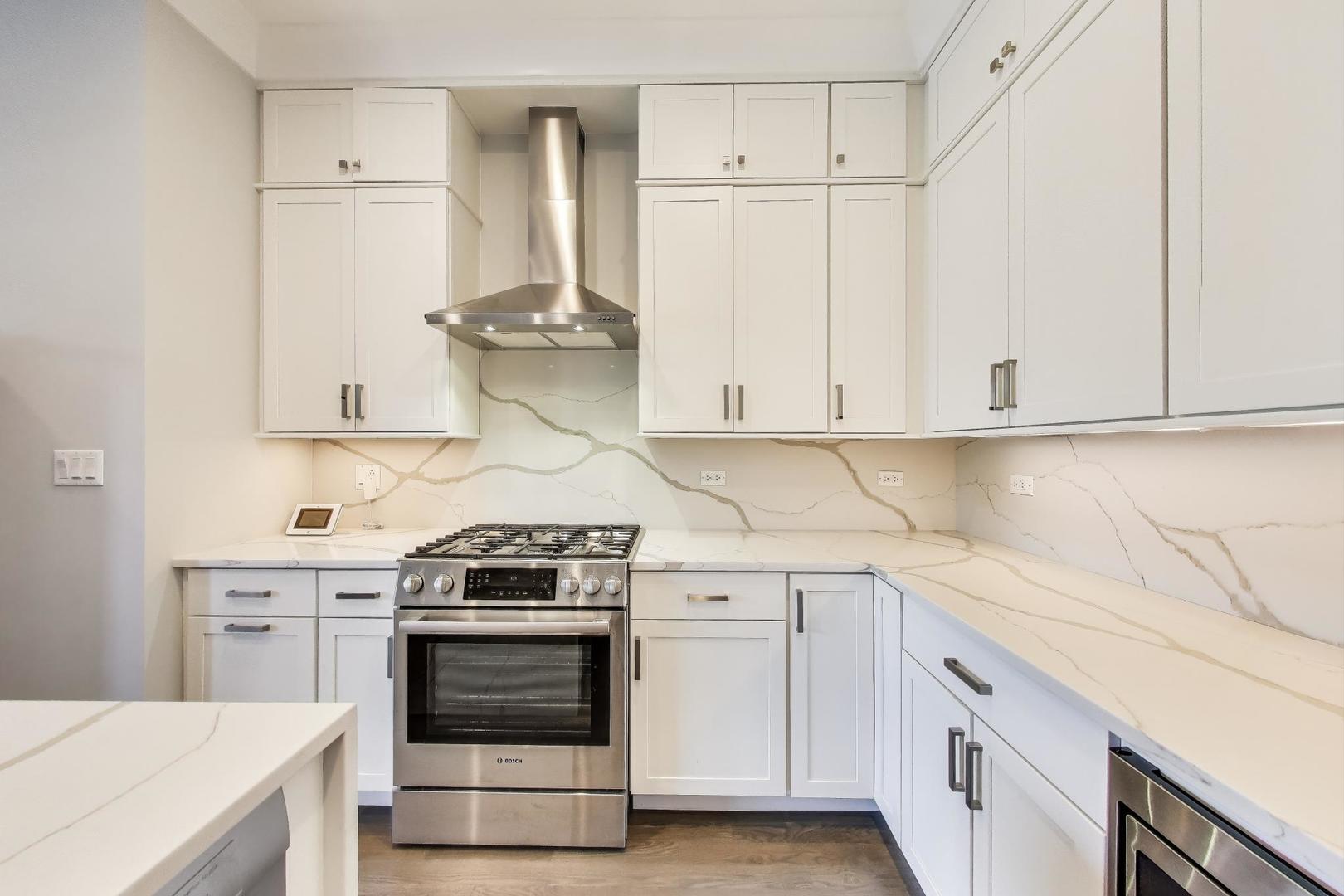 5748 North Hermitage Avenue, Unit 206 Chicago, IL 60660 - Photo 2 of 19 a kitchen with stainless steel appliances white cabinets and white appliances