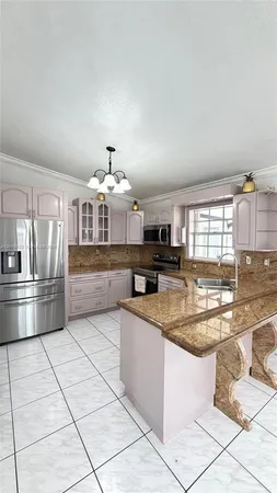 a kitchen with stainless steel appliances granite countertop a stove top oven a refrigerator a sink and dishwasher