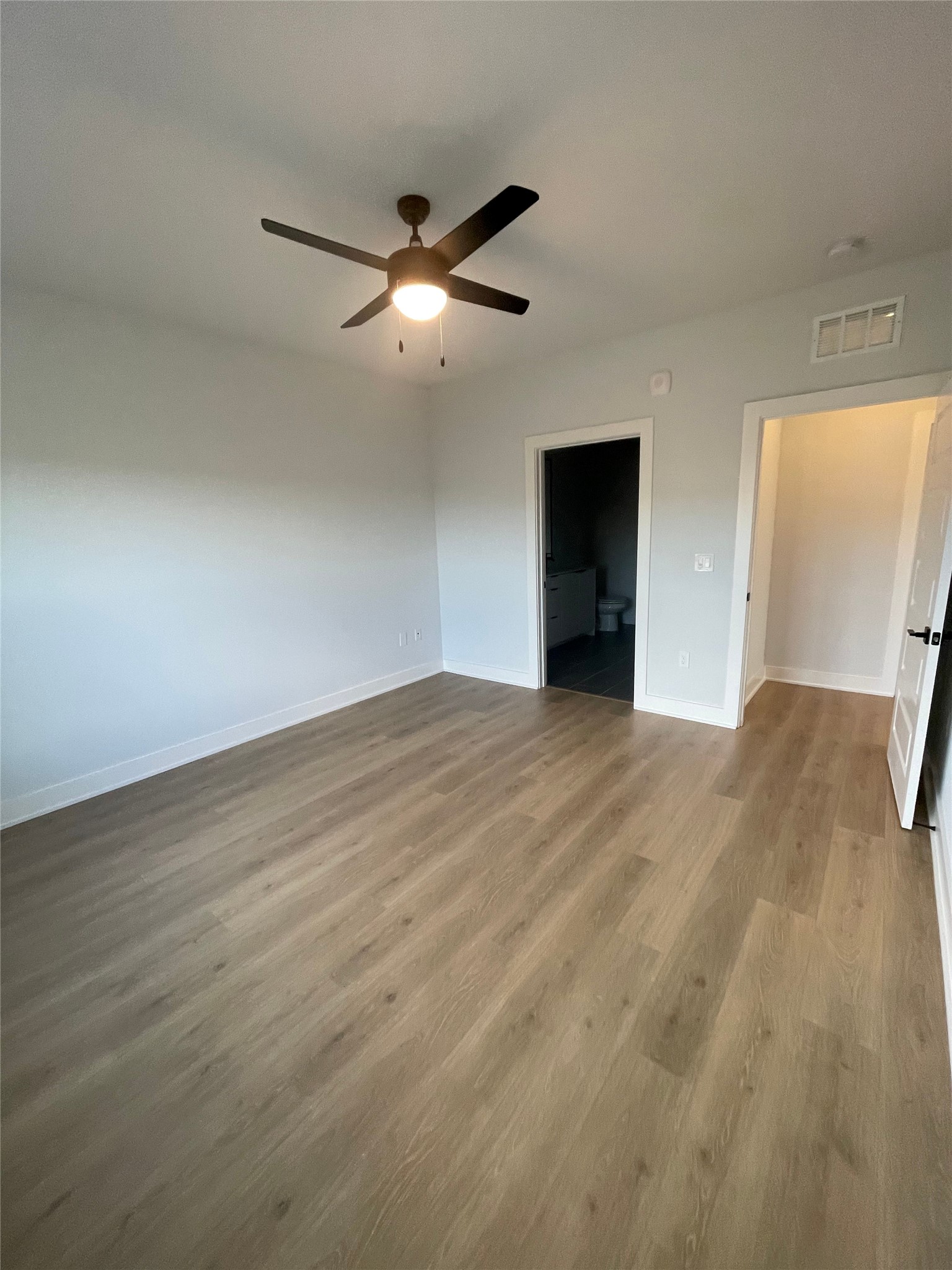 2500 Longview Street, Unit 400 Austin, TX 78705 - Photo 5 of 14 an empty room with wooden floor fan and windows