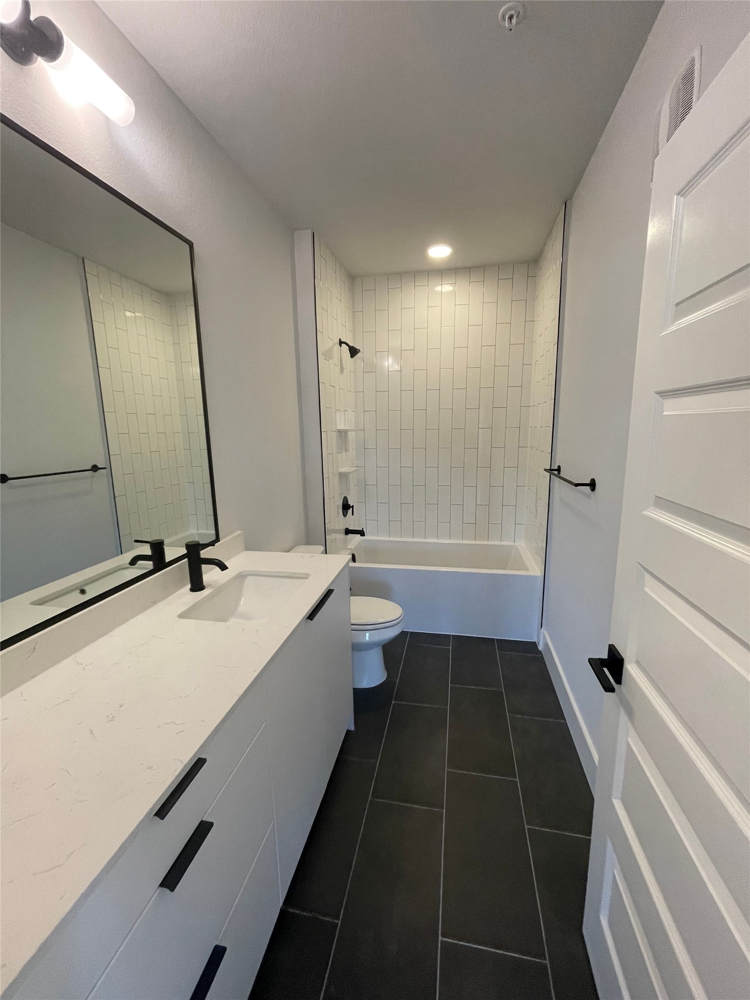 2500 Longview Street, Unit 400 Austin, TX 78705 - Photo 10 of 14 a bathroom with a double vanity sink toilet mirror and bathtub