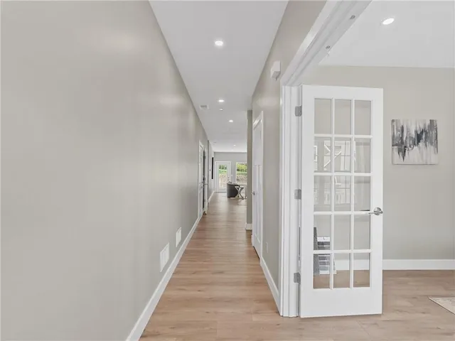 a view of a hallway with wooden floor and windows
