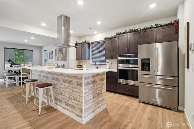 a kitchen with kitchen island white cabinets and stainless steel appliances