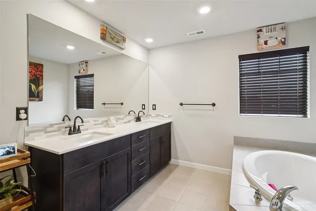 a bathroom with a double vanity sink and a mirror