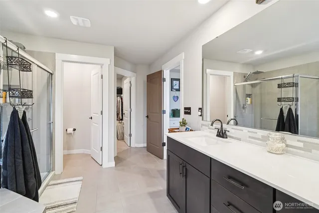 a bathroom with a sink a toilet and a large mirror