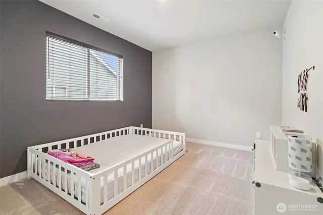 a white bed sitting in a bedroom next to a window