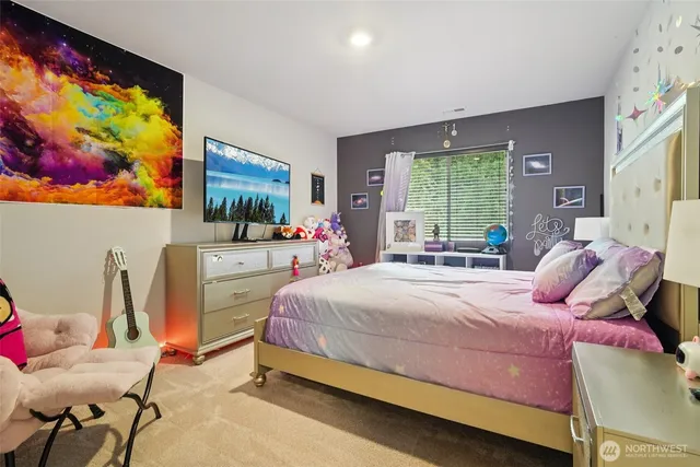 a bedroom with a bed and large windows