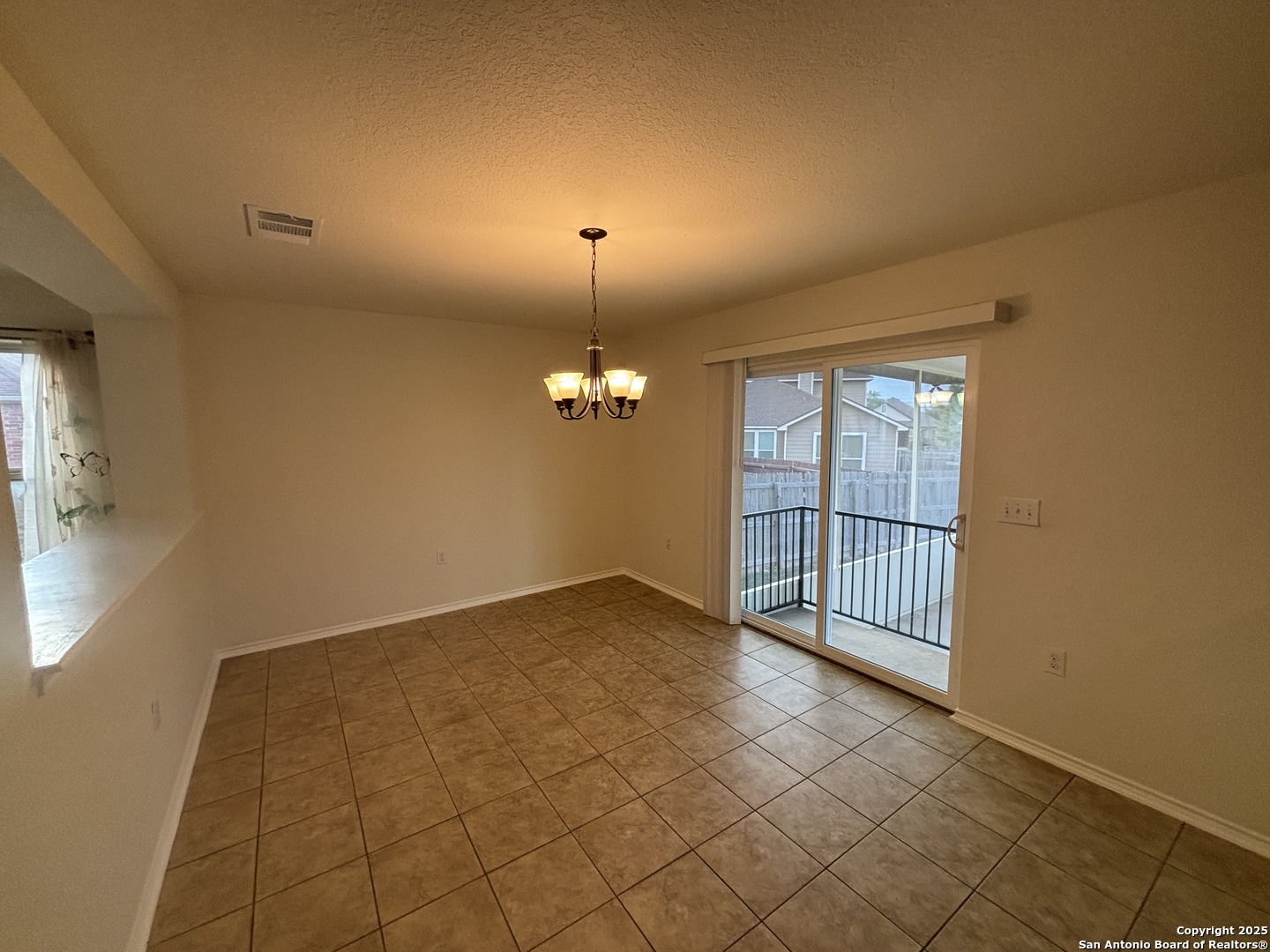 7370 Azalea Square San Antonio, TX 78218 - Photo 18 of 38 an empty room with chandelier and windows
