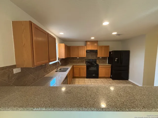 a kitchen with stainless steel appliances granite countertop a refrigerator and a sink