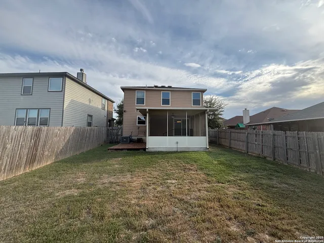 a view of a yard in front of a house with wooden fence