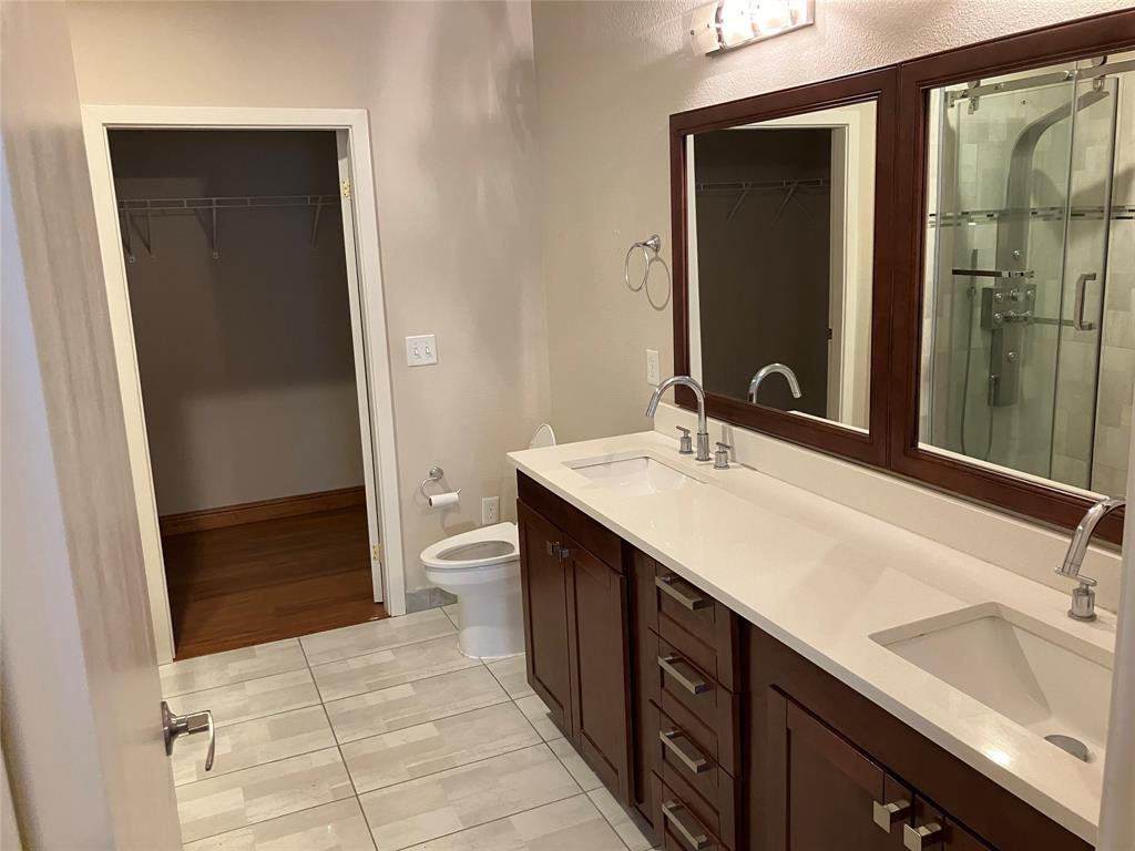 1220 West Trinity Mills Road, Unit 5009 Carrollton, TX 75006 - Photo 8 of 25 a bathroom with a double vanity sink toilet and shower