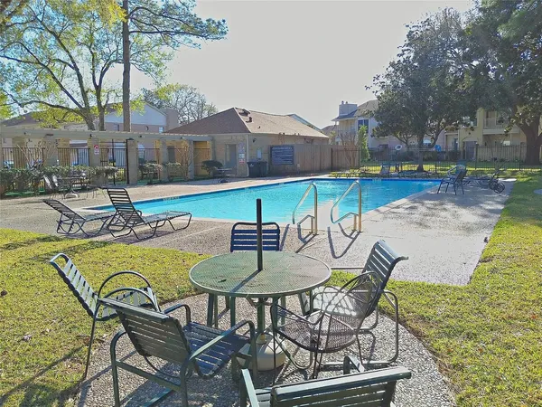 a swimming pool with outdoor seating and yard