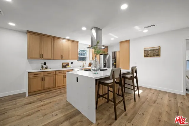 a kitchen with a sink cabinets and wooden floor