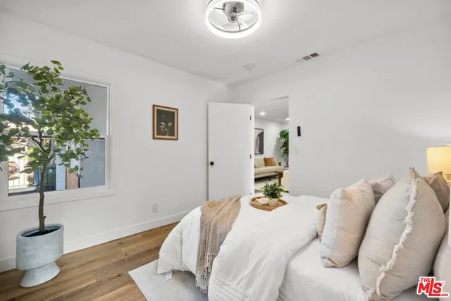 a bedroom with bed and a potted plant