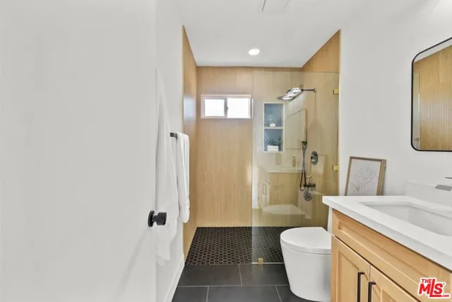a bathroom with a granite countertop sink a toilet and shower