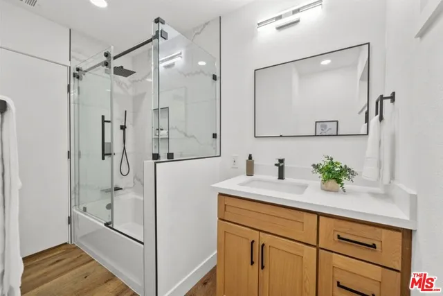 a bathroom with a shower sink and mirror