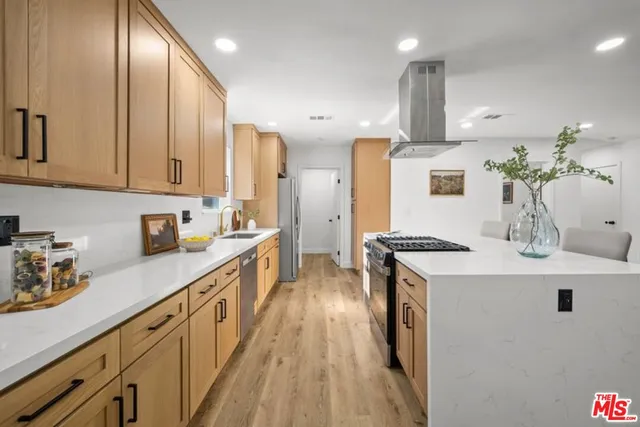 a kitchen with stainless steel appliances sink stove and cabinets
