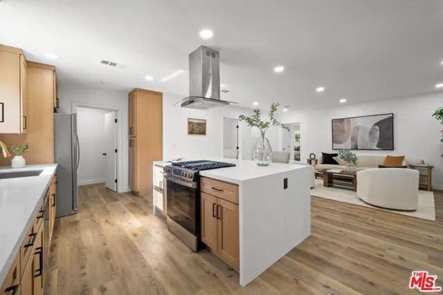 a kitchen with stainless steel appliances a stove a sink a refrigerator and cabinets