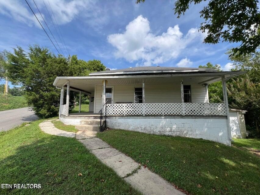 121 Sexton Lane Oneida, TN 37841 - Photo 1 of 32 a front view of a house with a garden and yard
