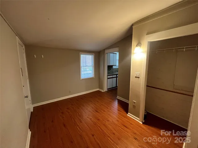 an empty room with wooden floor and a window