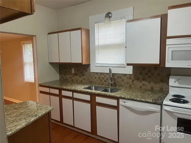 a kitchen with stainless steel appliances granite countertop a sink stove and cabinets